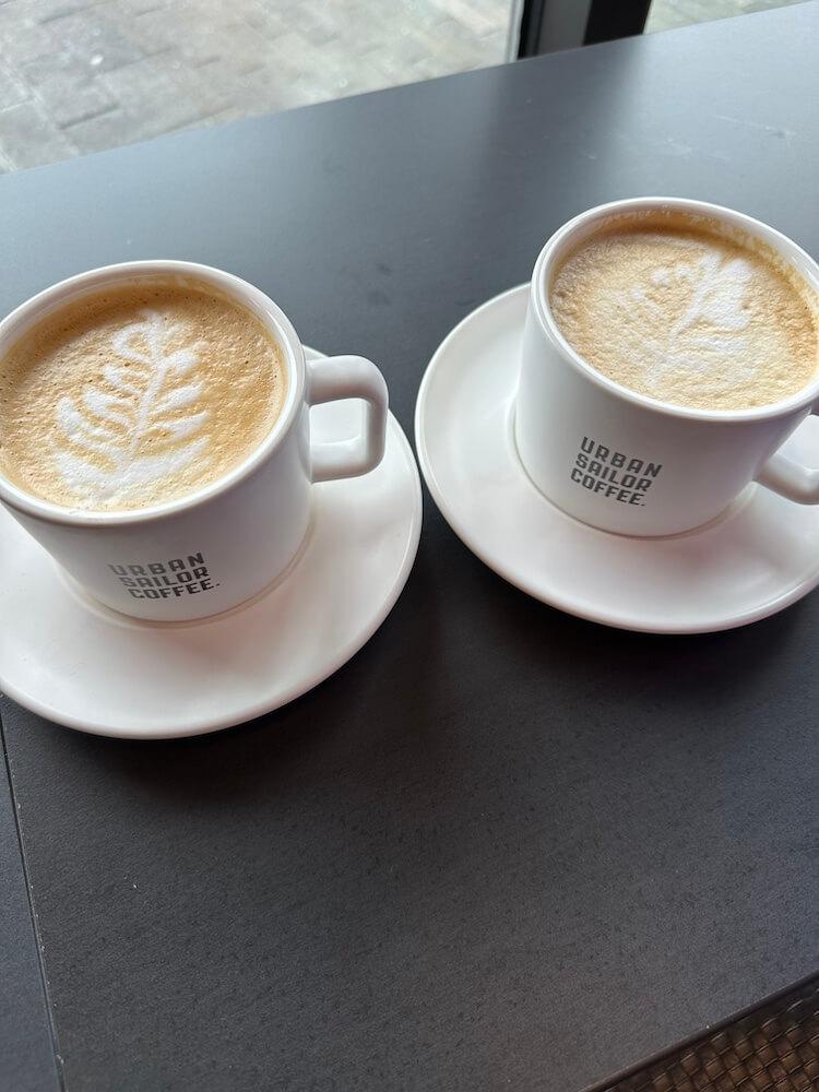 Two cafe lattes in mugs with latte art.