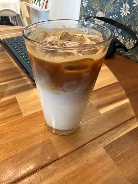 16 oz glass of iced latte. Bottom half shows milk and top is the brown espresso unmixed.