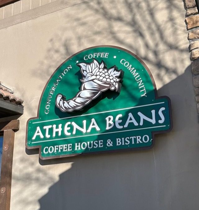 Green with white lettering outdoor sign that says :Athene Beans Coffee House & Bistro "sign.