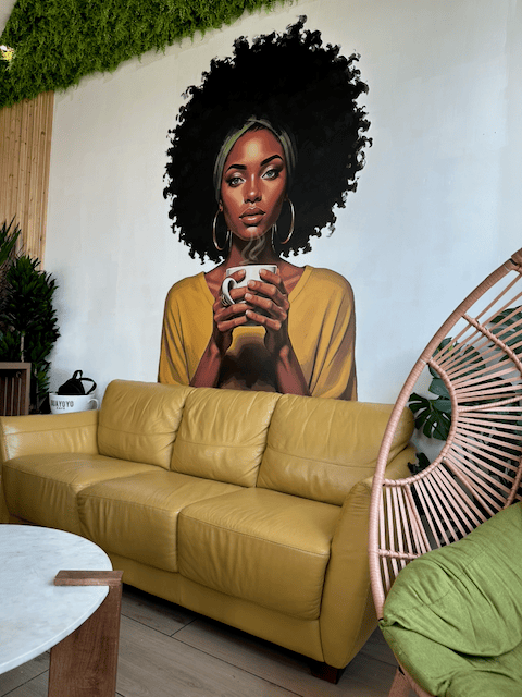 A colorful coffee mural and lounge seating inside Guayoyo Café.