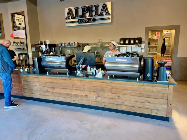 The counter and busy ordering area at Alpha Coffee.